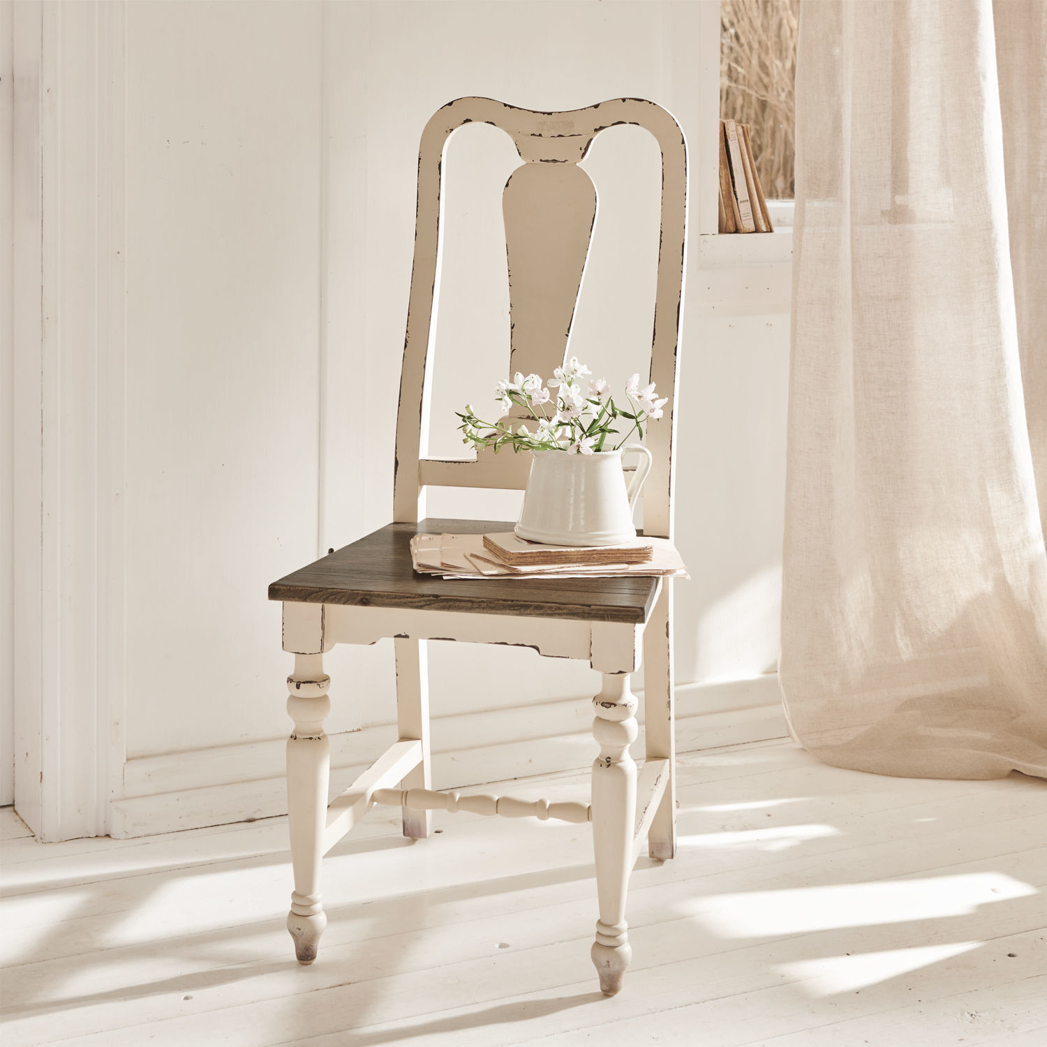 Stuhl Harry Weisser Holzstuhl im Vintage-Stil mit dunklem Sitz und Krug mit Blumen in hellem Raum
