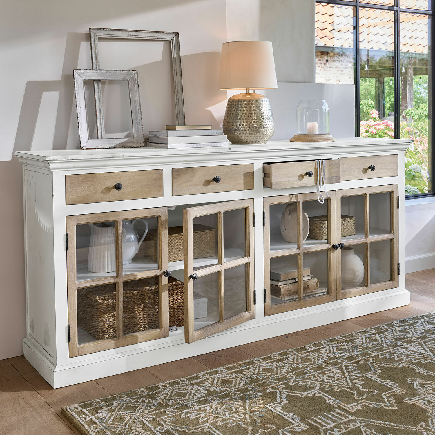 Kommode Marshwood Weiße Holzkommode mit Schubladen und Glastüren, Dekoration und Lampe auf der Ablage
