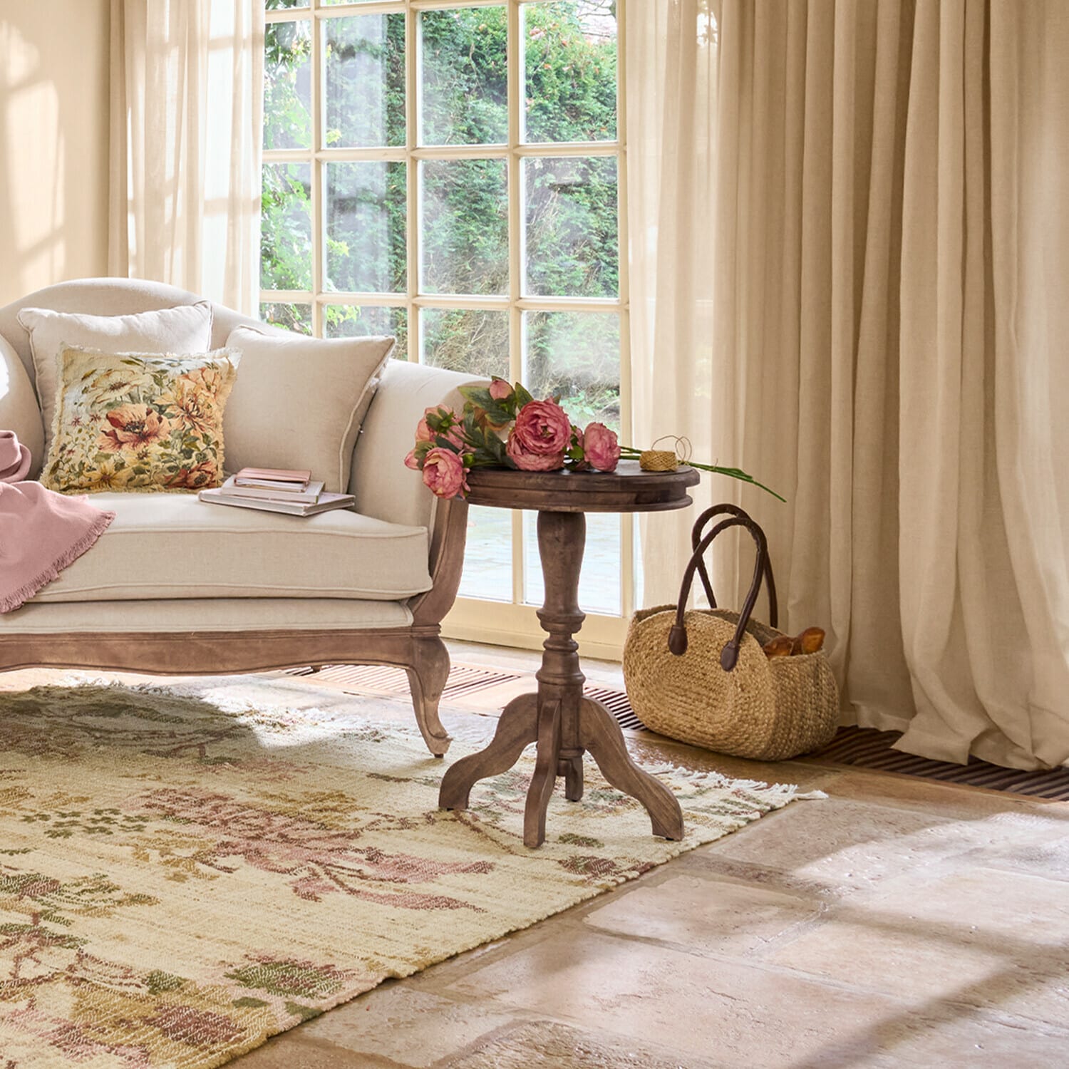 Gemütliches Wohnzimmer mit beigem Sofa, Holzbeistelltisch und Blumen auf floralem Teppich