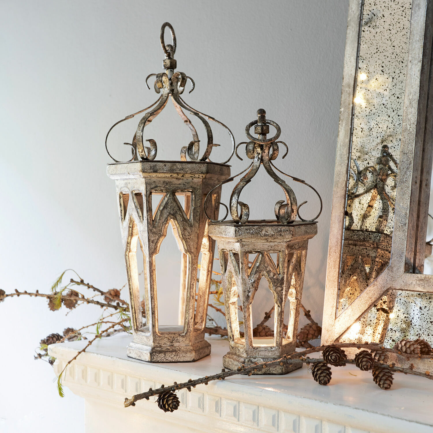 Deko-Objekt 2er Set Morvant Dekorative Metalllaternen im Vintage-Stil in Antiksilber auf Kaminsims mit Kiefernzapfen