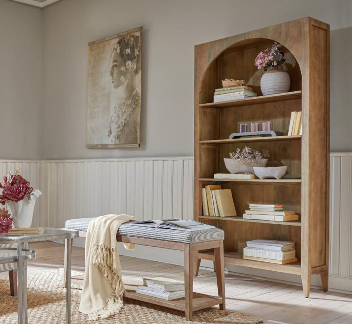 Holzregal mit Bogenöffnung, Dekorationen und Büchern in hellem, natürlichem Wohnzimmer