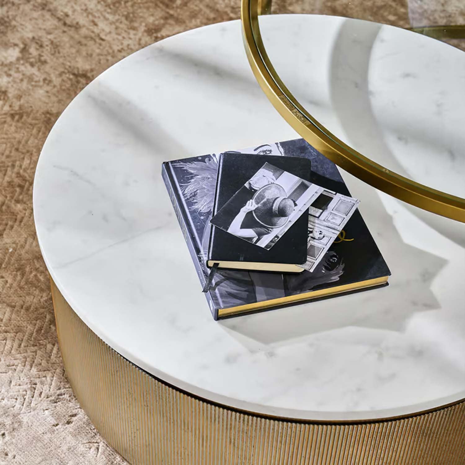 Runder Couchtisch mit weisser Marmorplatte und goldener Basis auf beigem Teppich
