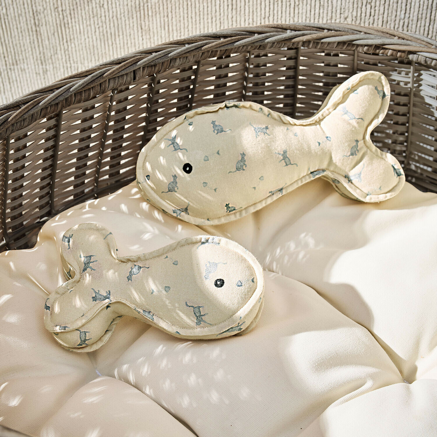 Beige Fischkissen mit Katzenmuster auf Rattansessel mit hellem Polster