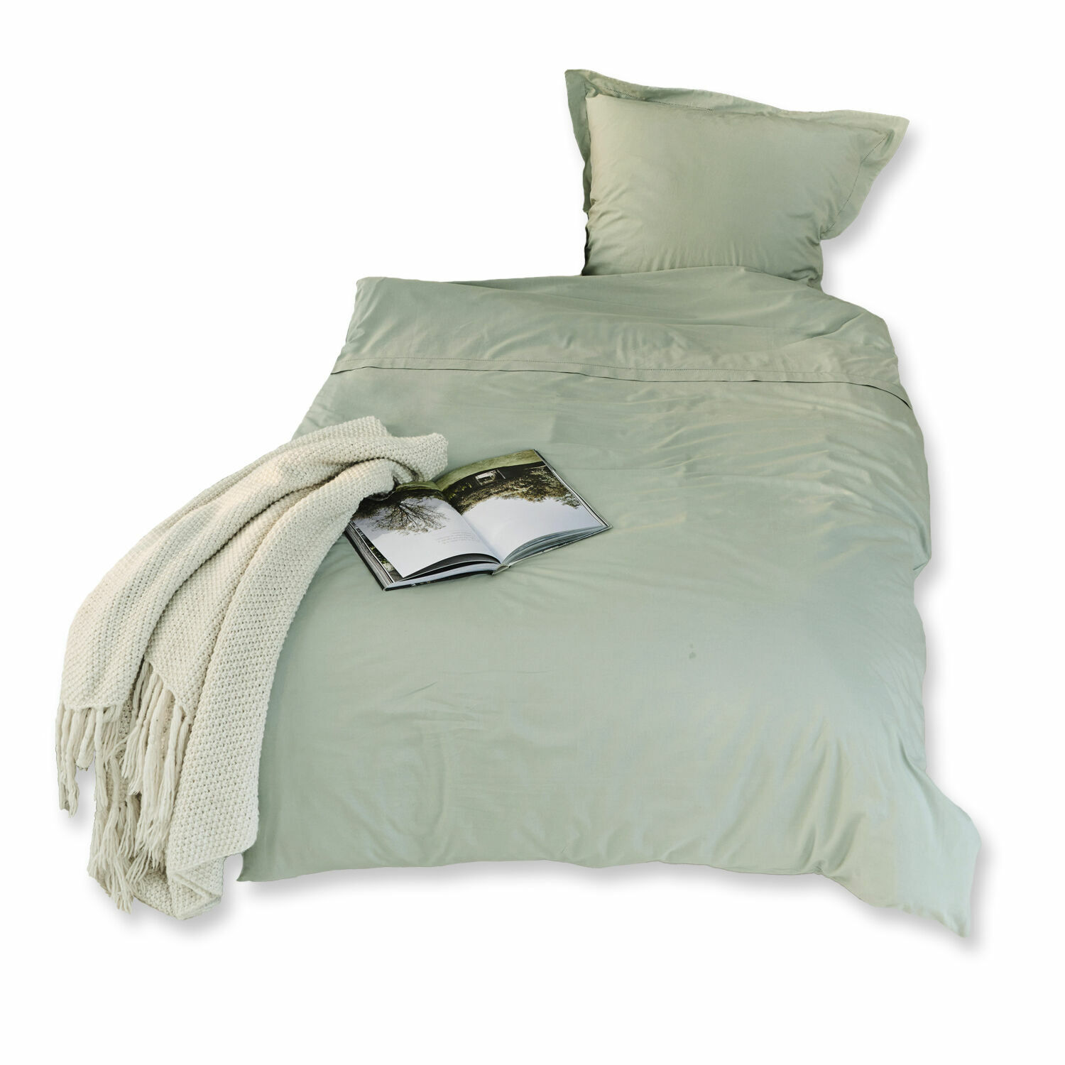 Grüne Grosseto-Bettwäsche aus weicher Baumwolle mit cremefarbenem Plaid und Buch auf dem Bett.