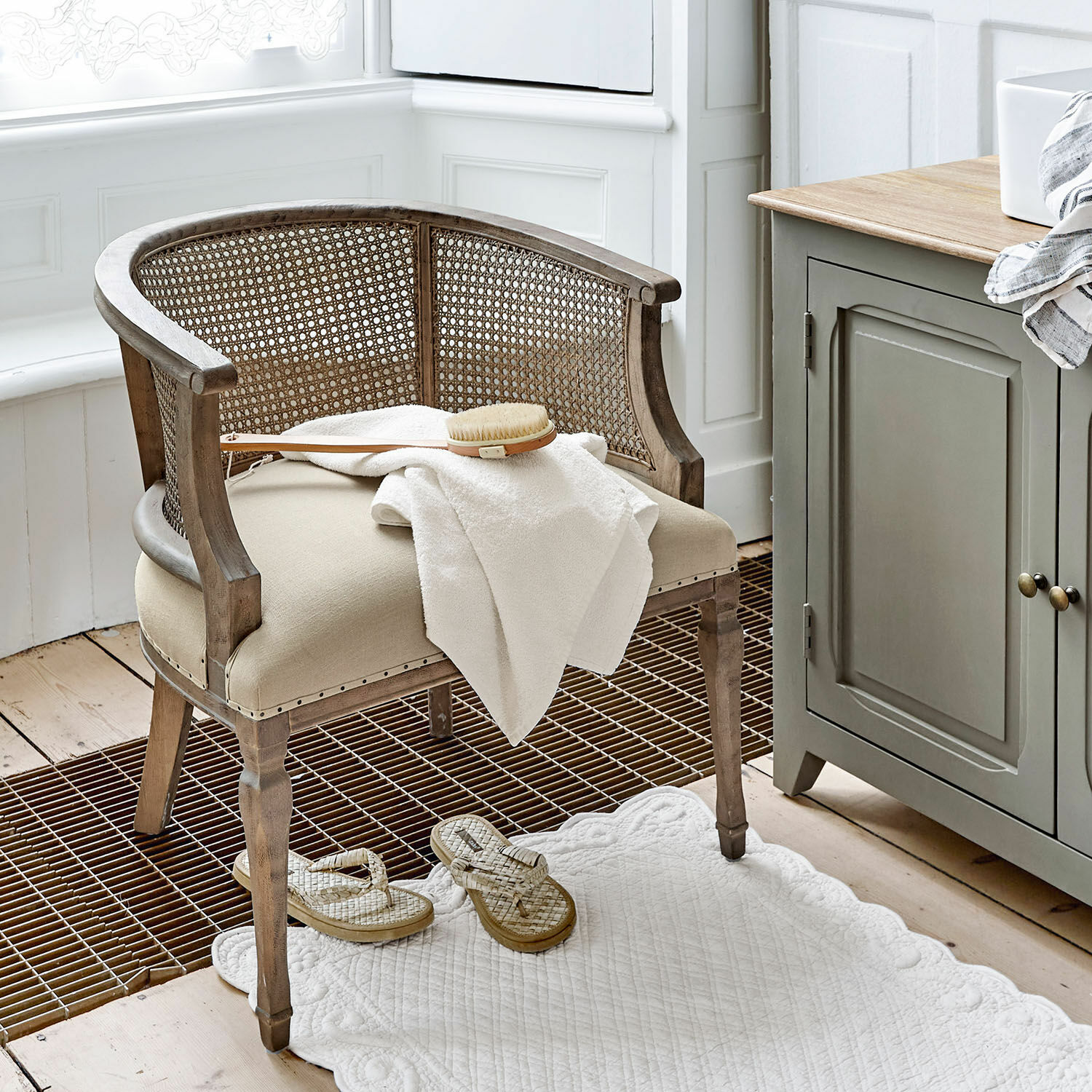 Stuhl Curbigny Stuhl aus Holz und Rattan in Beige mit gepolstertem Sitz und weissem Handtuch im Badezimmer
