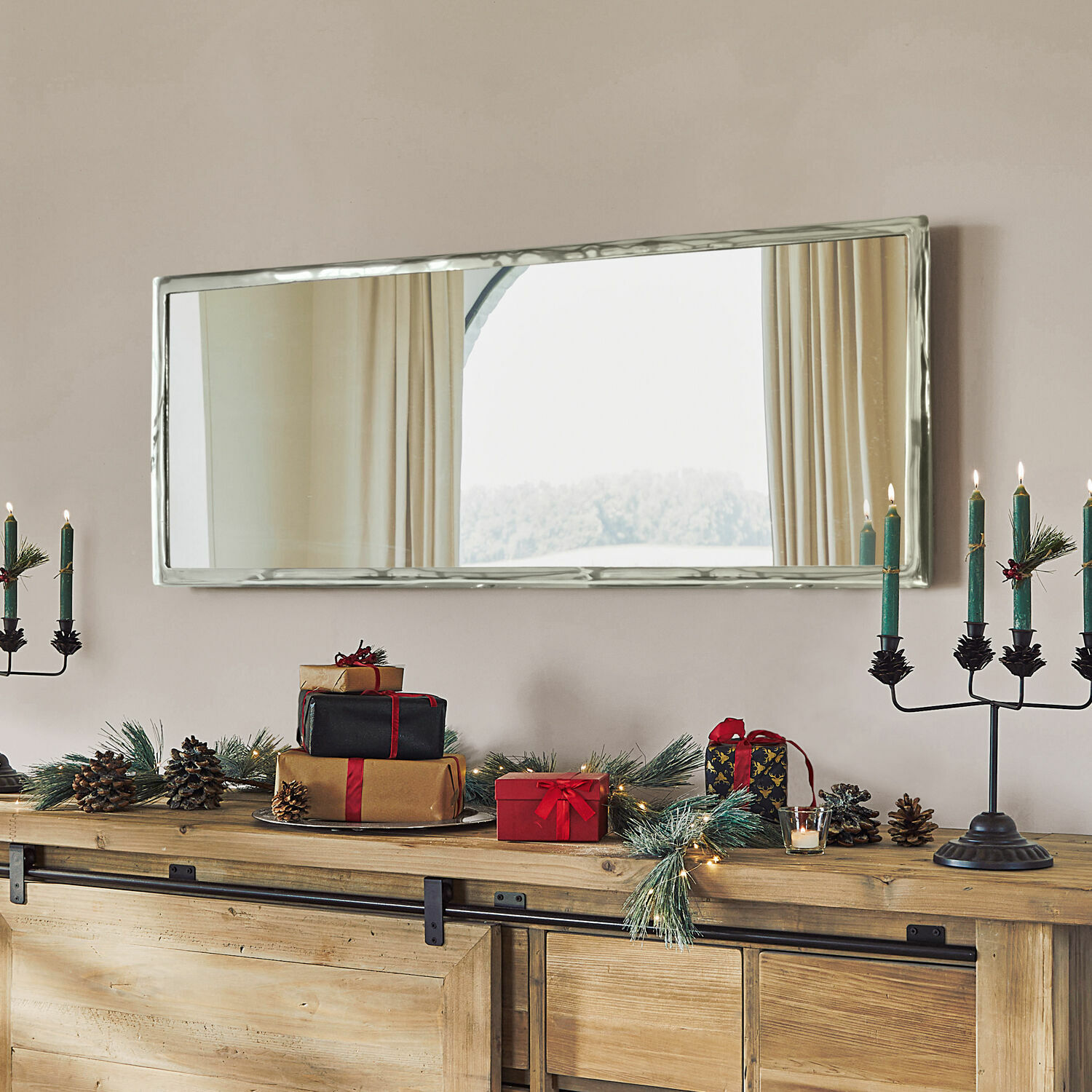Rechteckiger Spiegel mit silbernem Metallrahmen über Holzkommode mit Weihnachtsdekoration