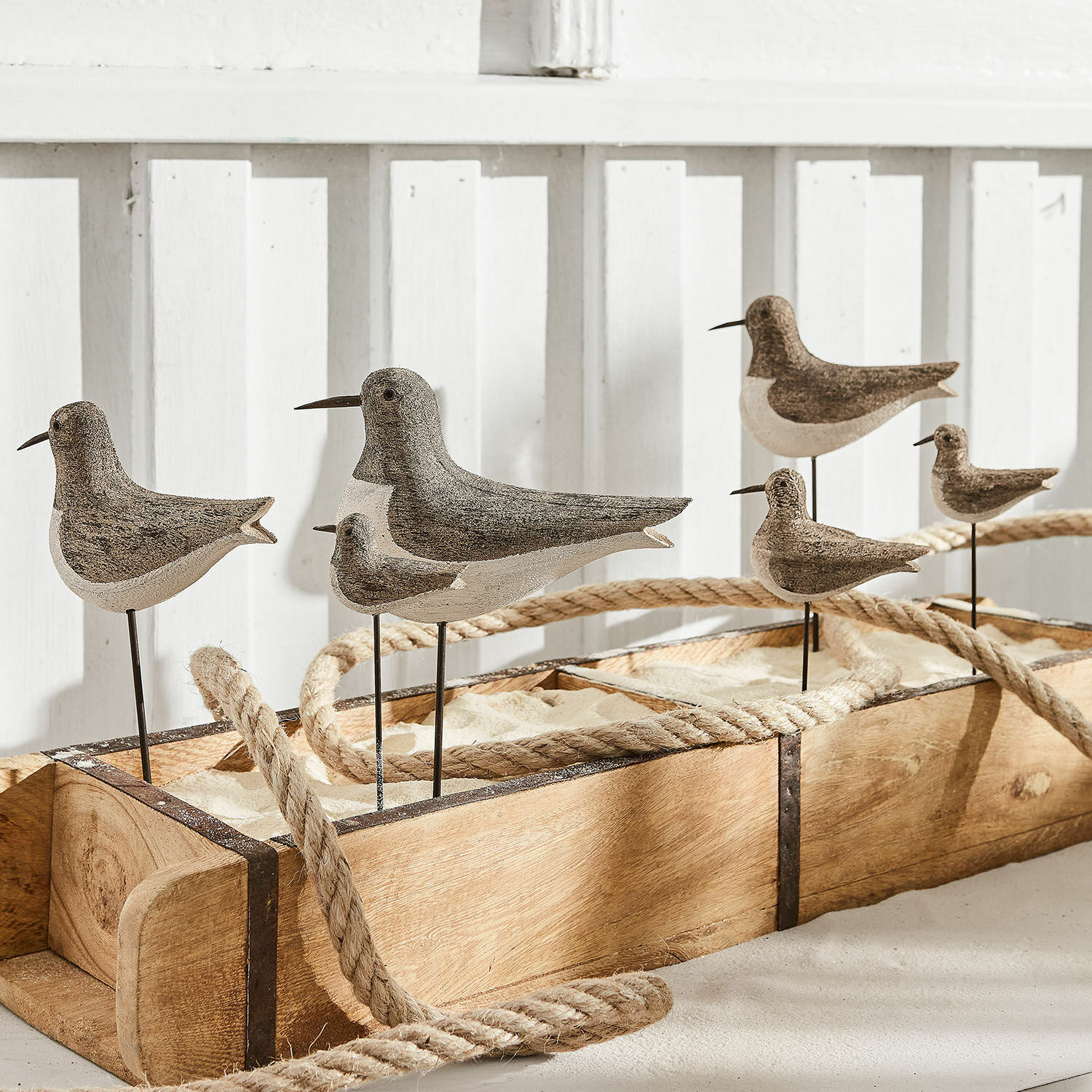 Dekorative Vögel aus Holz und Metall in Naturfarben auf Holzsockel mit Sandfüllung