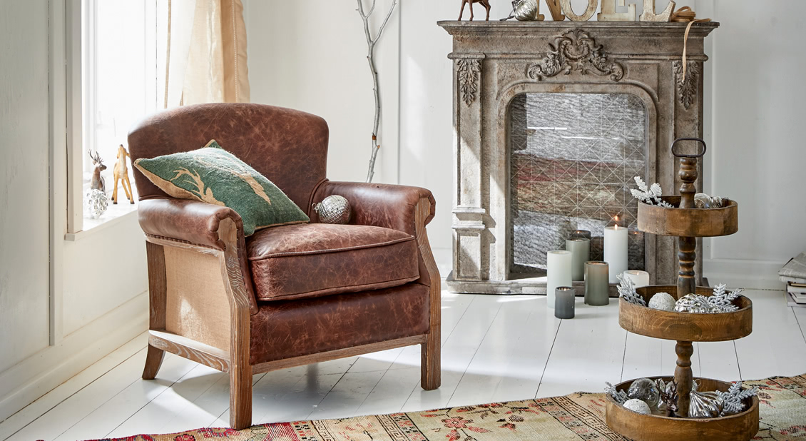 Brauner Ledersessel mit Holzgestell im hellen Wohnzimmer mit Weihnachtsdekoration und Cheminée