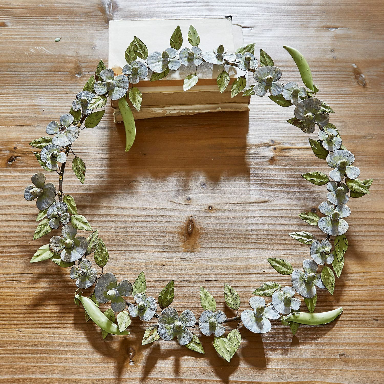 Kranz Cecilia Metallkranz mit grünen Blättern und weissen Blüten auf Holztisch als Dekoration