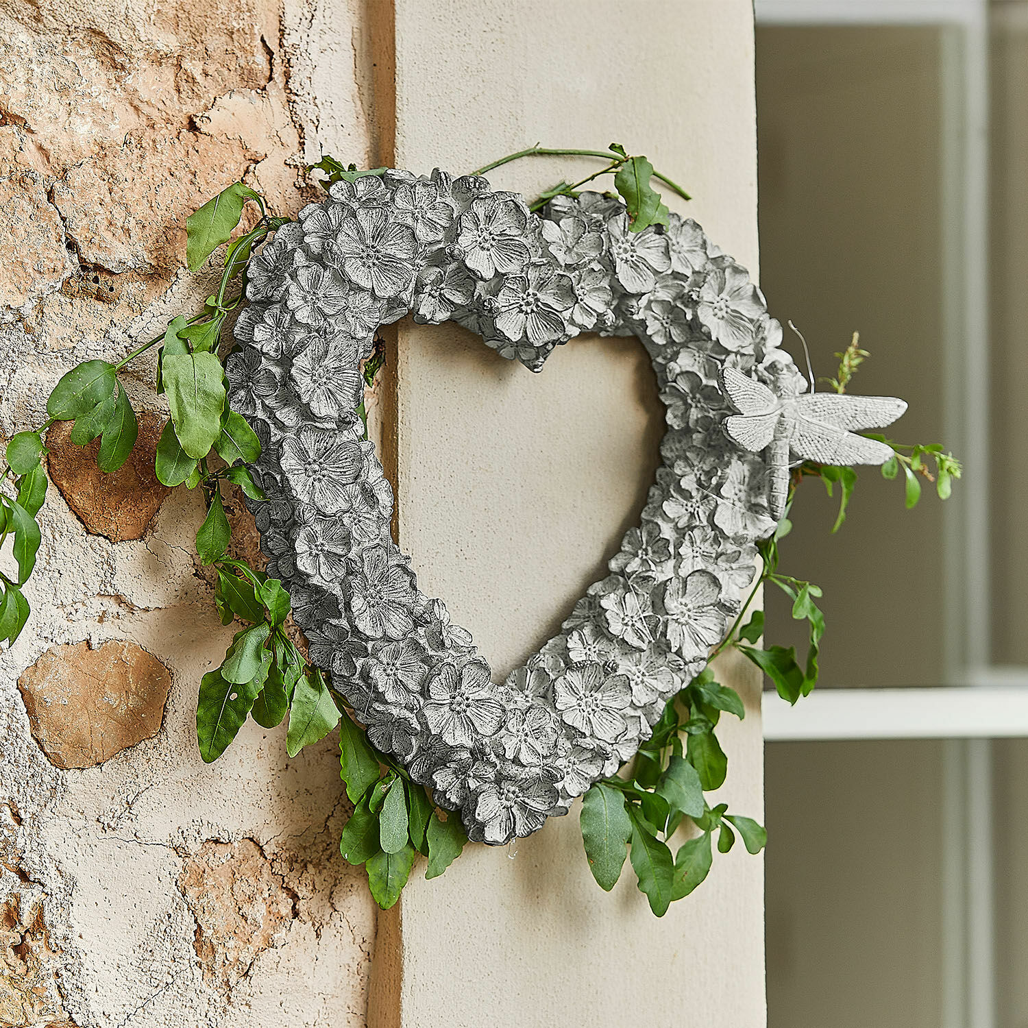 Kranz Corvelique Dekoratives Herz aus grauem Metall mit Blumen, grünen Blättern und Libelle zum Aufhängen an der Wand
