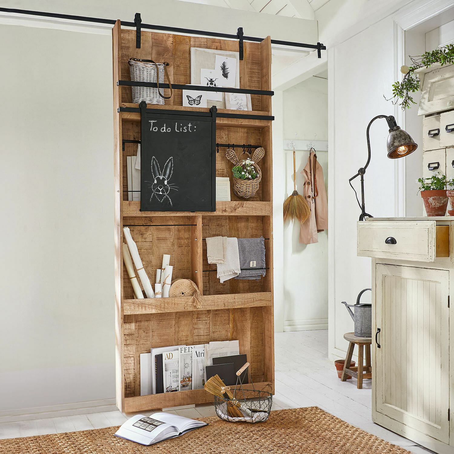 Schiebetür Vulmont Holzregal mit Kreidetafel und Dekorationen in hellem Raum mit Juteteppich
