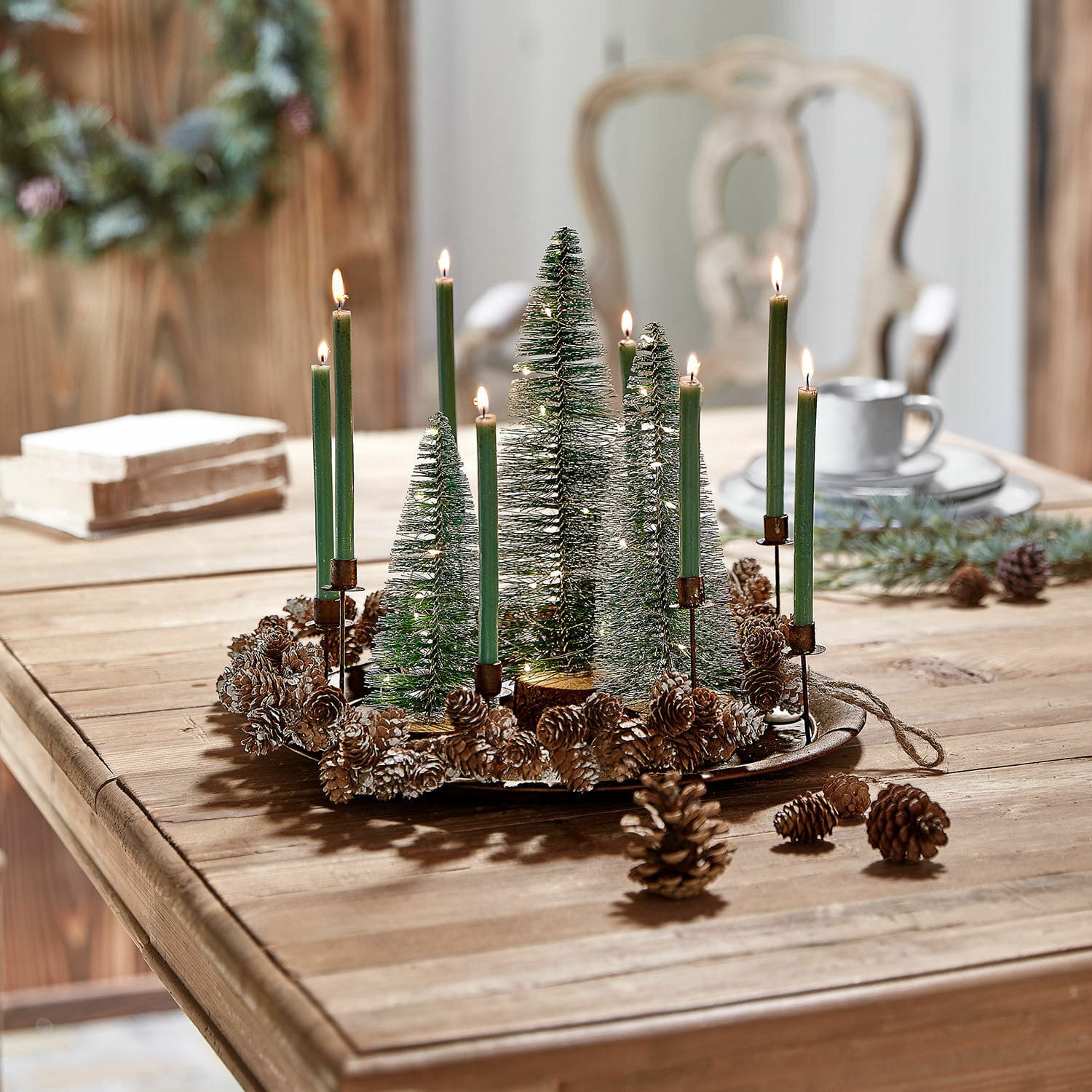 Kerze 20er Set Lysarion Weihnachtlicher Dekokranz mit grünen Kerzen und Tannenzapfen auf Holztisch