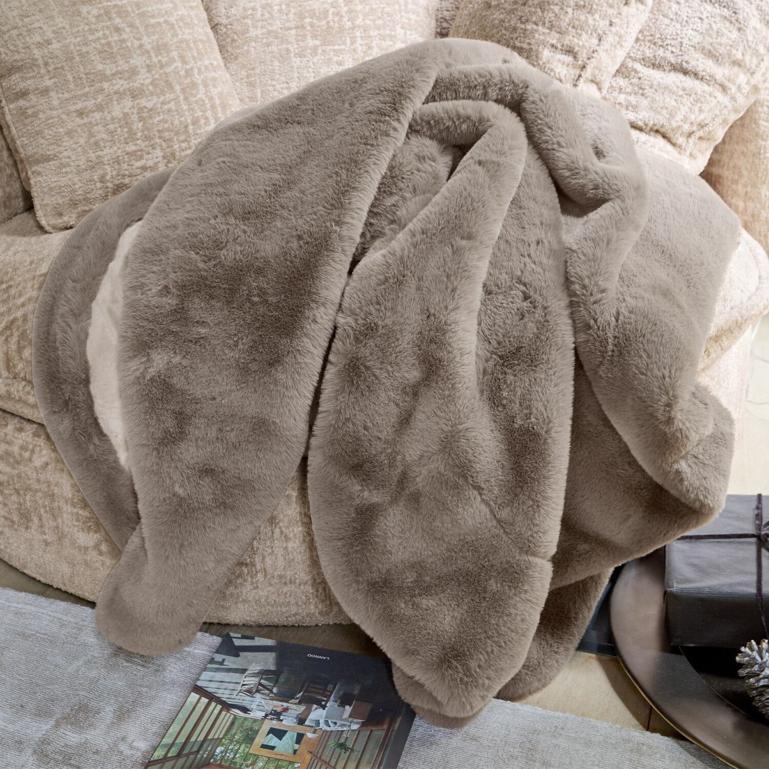 Plaid Brisvento Weiche beiger Kunstfell-Decke auf dem Sofa, ideal für eine gemütliche Wohnraumgestaltung und Dekoration.