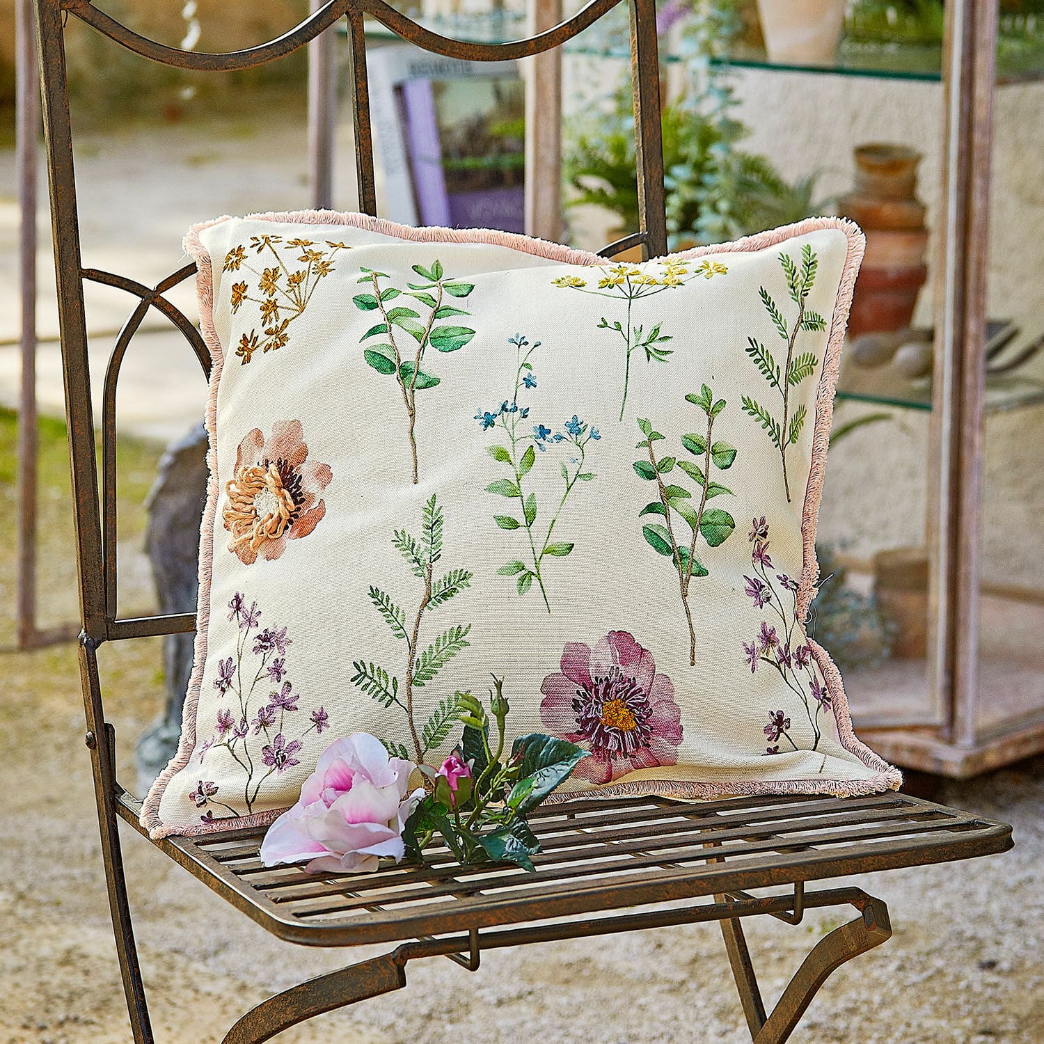 Kissenhülle Fahzoura Dekoratives Baumwollkissen in Creme mit Pflanzenmuster und rosa Fransen für Gartenmöbel.
