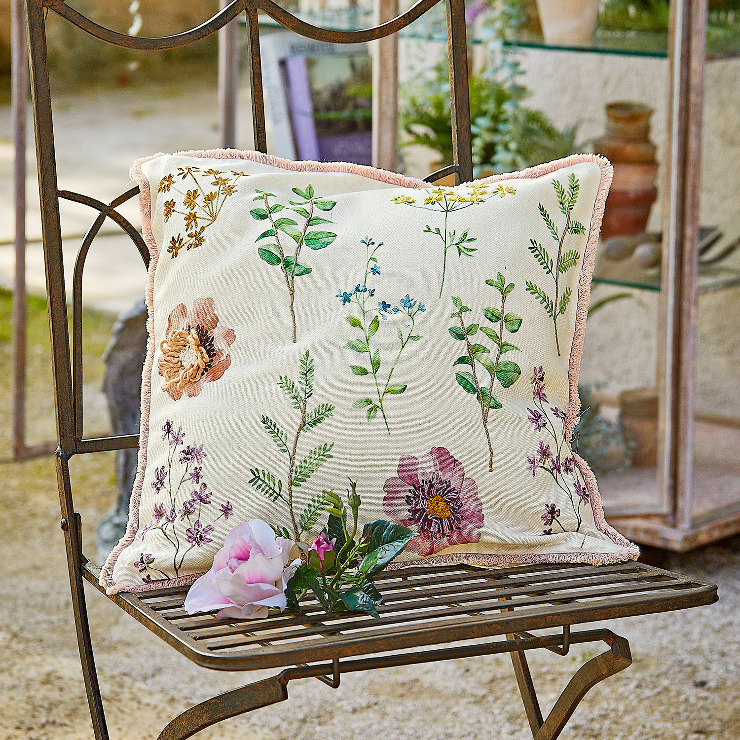 Kissenhülle Fahzoura Dekoratives Baumwollkissen in Creme mit Pflanzenmuster und rosa Fransen für Gartenmöbel.