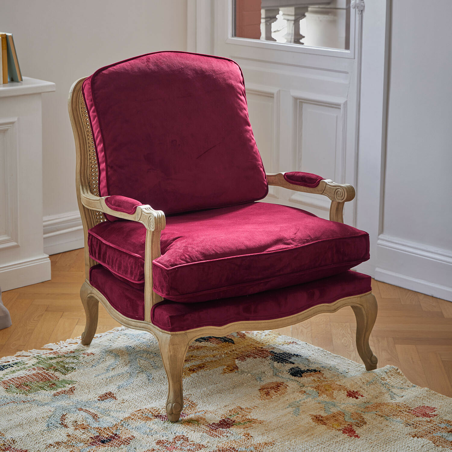 Sessel aus hellem Holz mit bordeauxroten Samtkissen, klassischer Stil und Komfort