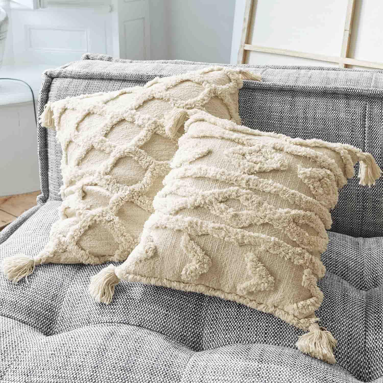 Beige Baumwoll-Dekokissen mit Quasten auf grauem Sofa, strukturierte Muster und Design