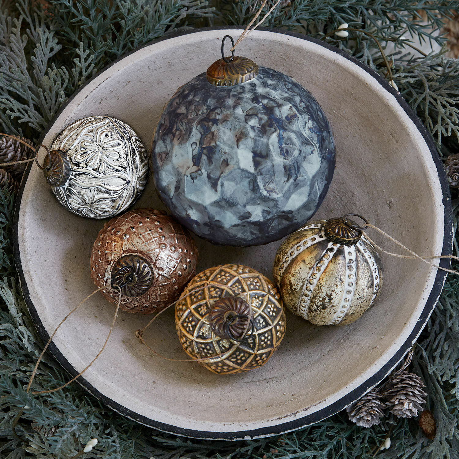 Weihnachtsschmuck 5er Set Jilian Dekorative Weihnachtskugeln aus Metall in verschiedenen Farben in einer Keramikschale auf grünem Hintergrund