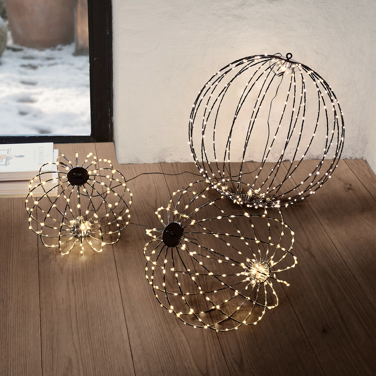 Zwei dekorative LED-Lichtkugeln in warmweiß auf dem Boden eines modernen Wohnzimmers