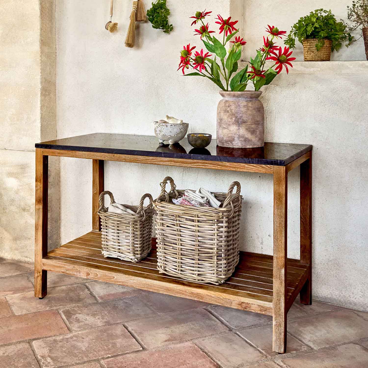 Holztisch mit schwarzer Platte und zwei Korbaufbewahrungen, dekoriert mit roten Blumen