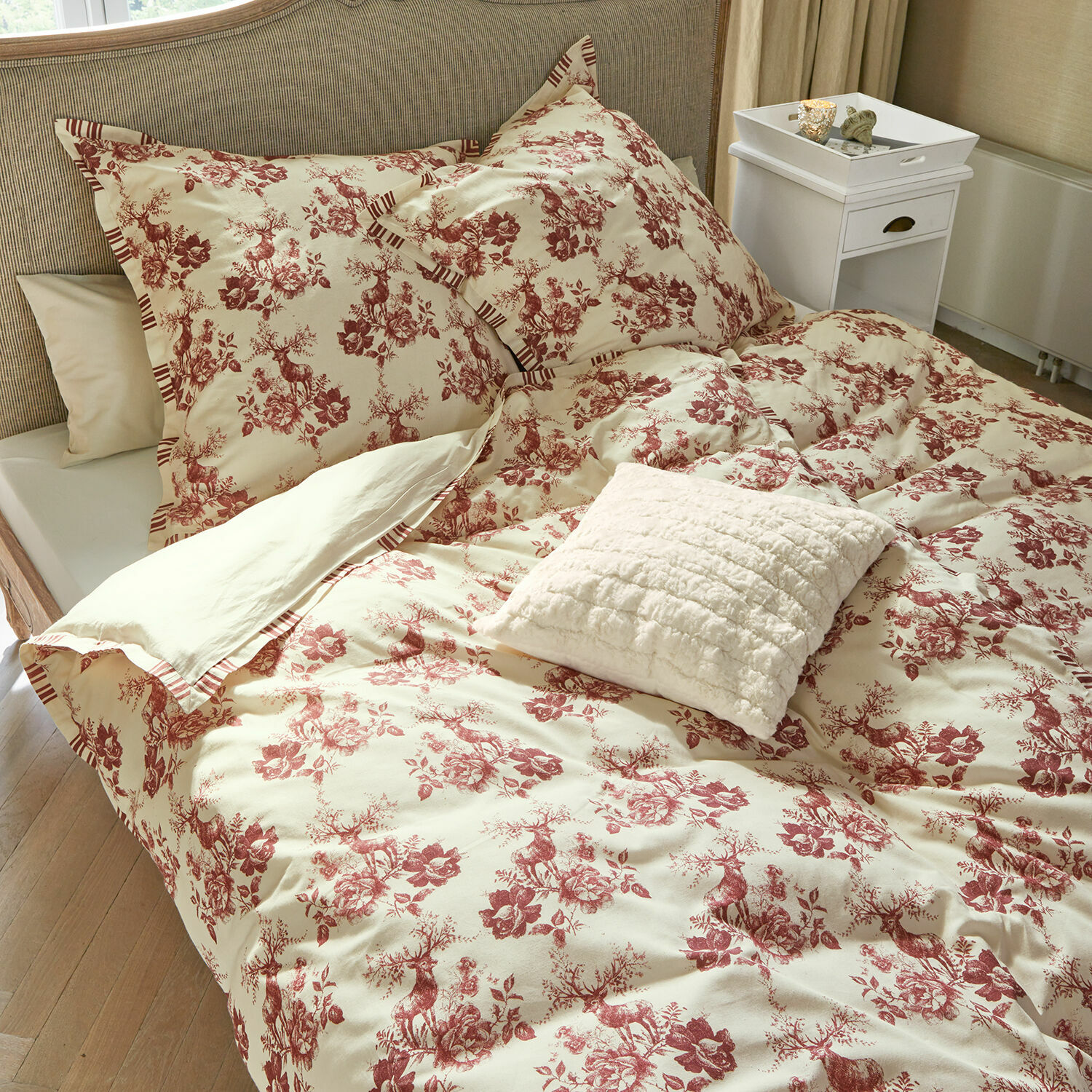 Bettwäsche Renique Bettwäsche aus Baumwolle in Creme mit rotem Hirsch- und Blumenmuster, dekoratives Kissen auf dem Bett.