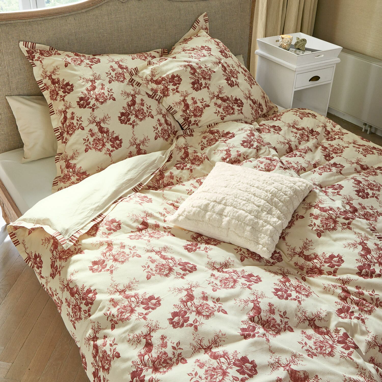 Bettwäsche Renique Bettwäsche aus Baumwolle in Creme mit rotem Hirsch- und Blumenmuster, dekoratives Kissen auf dem Bett.