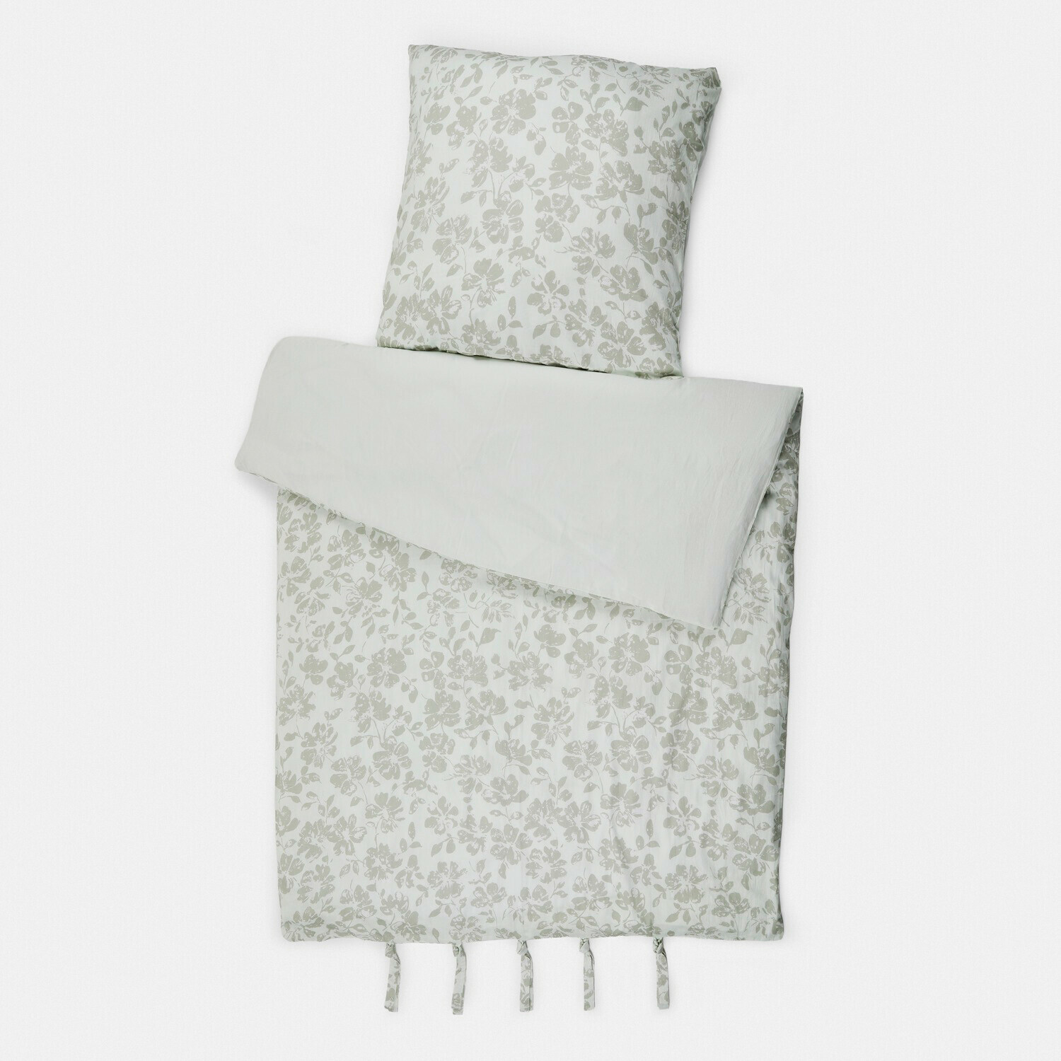 Bettwäsche aus hellem Baumwollstoff mit feinem Blumenmuster und Bändchen zum Fixieren