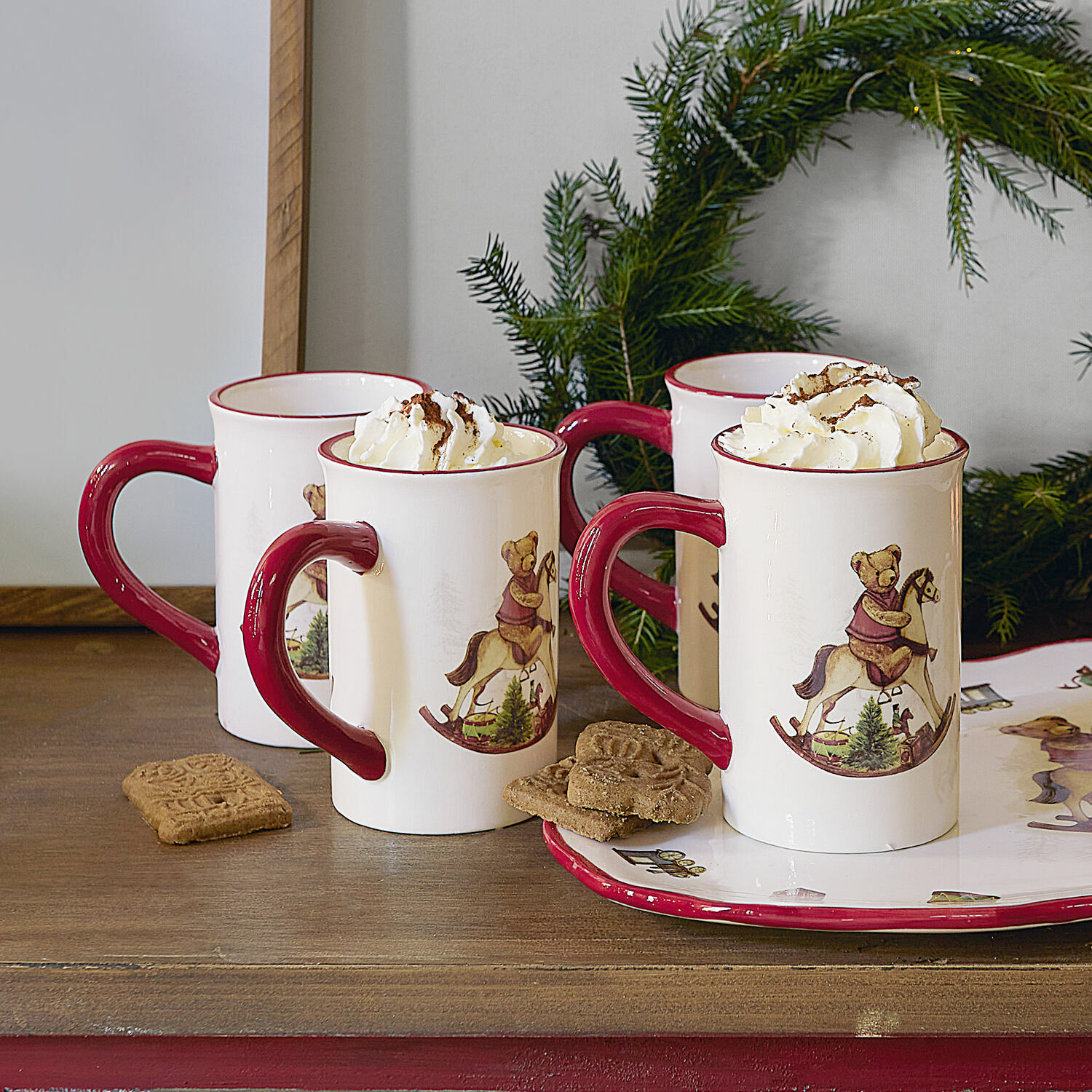 Tasse 4er Set Troms Keramiktassen mit rotem Henkel und Bärenmotiv auf Schaukelpferd, gefüllt mit Rahm, weihnachtlich dekoriert