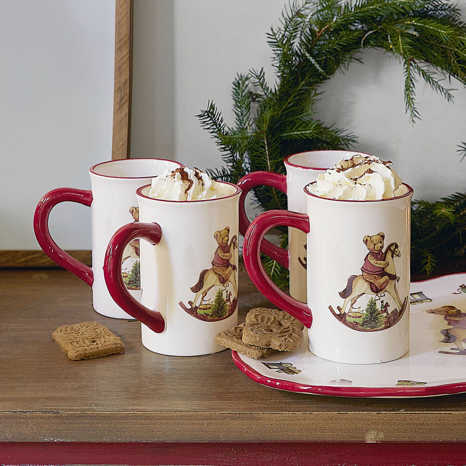 Tasse 4er Set Troms Keramiktassen mit rotem Henkel und Bärenmotiv auf Schaukelpferd, gefüllt mit Rahm, weihnachtlich dekoriert