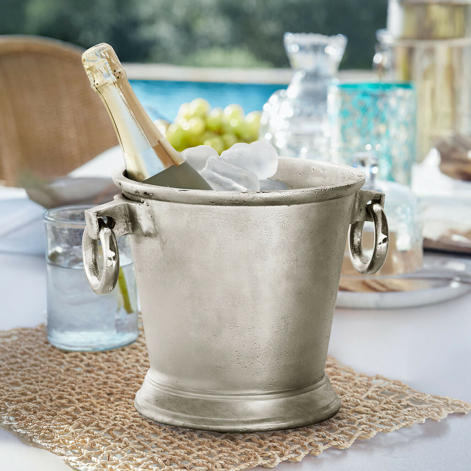 Getränkekühler Cressford Silberner Metall-Eiswürfeleimer mit Champagnerflasche und Eis auf Gartentisch