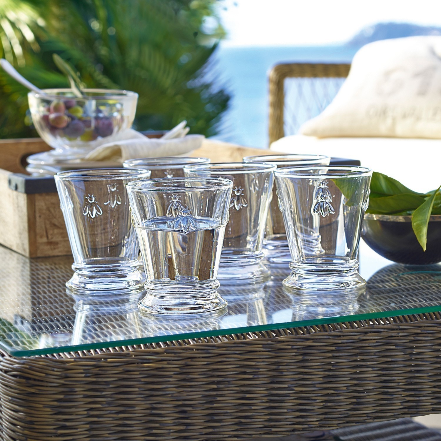 Wassergläser 6er Set Abeille Sechsteiliges Set aus klarem Glas mit Bienenmotiv auf Glastisch im Aussenbereich