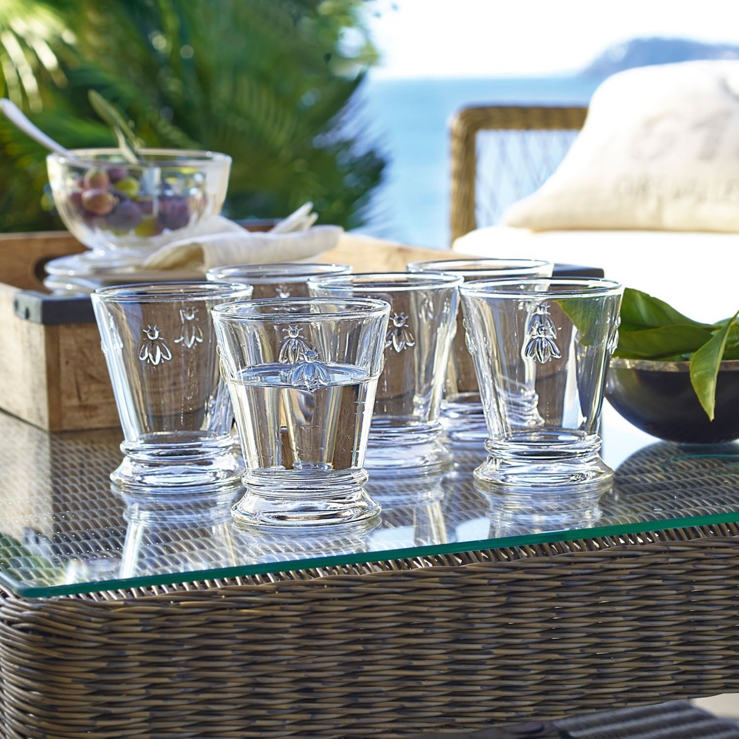 Wassergläser 6er Set Abeille Sechsteiliges Set aus klarem Glas mit Bienenmotiv auf Glastisch im Aussenbereich