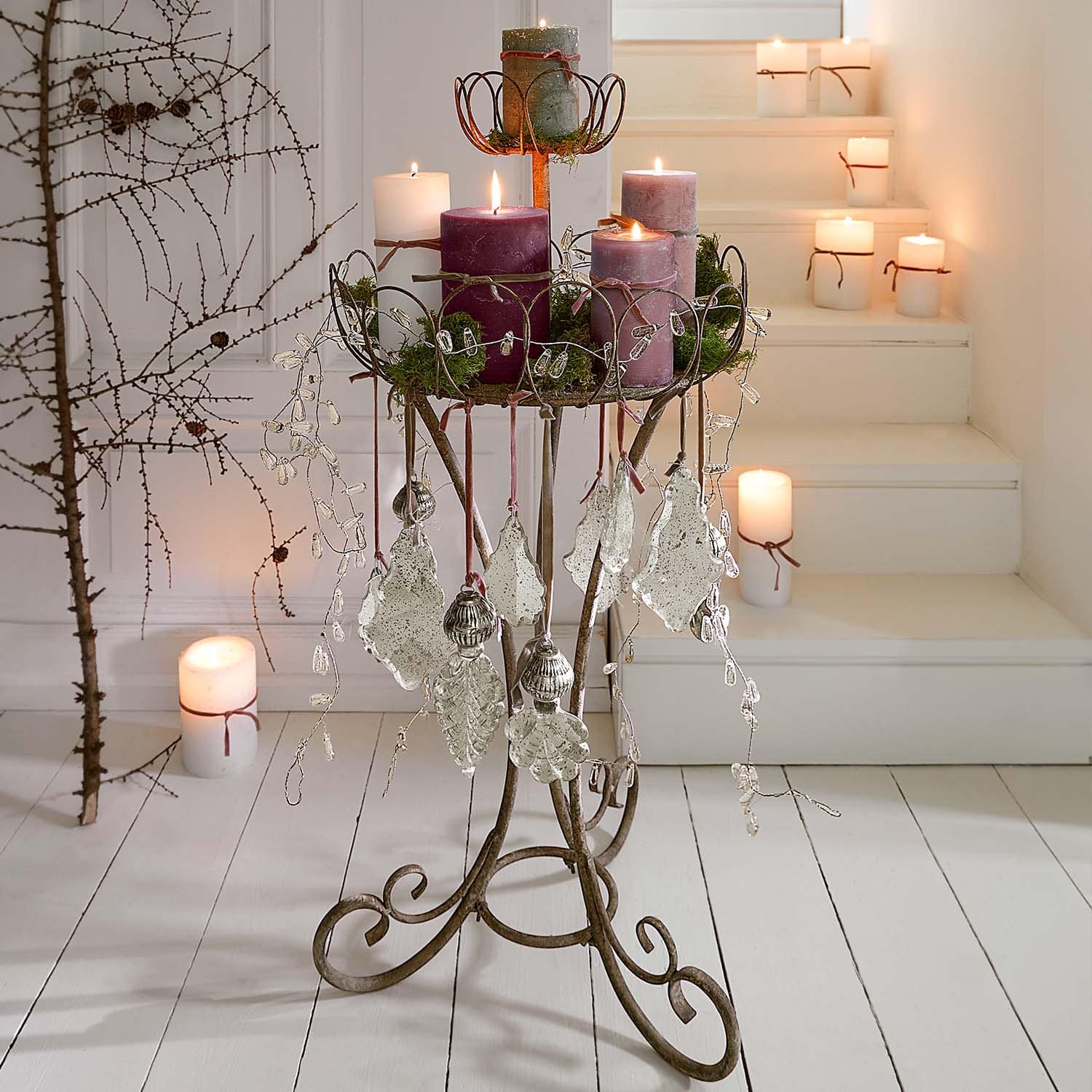 Metallkerzenhalter mit blattförmigen Anhängern und violetten Kerzen im rustikalen Design