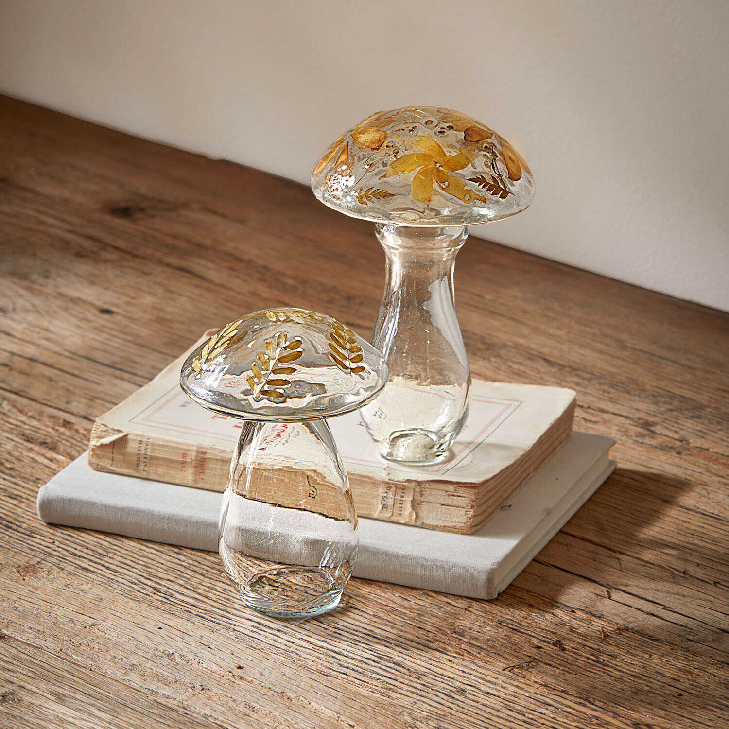 Deko-Pilz 2er Set Émurise Glasdekorationen in Pilzform mit getrockneten gelben Blumen auf Holztisch