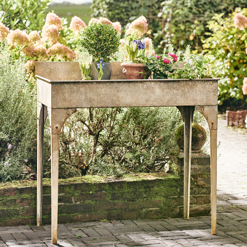 Beiger Metall-Gartentisch mit Blumen, ideal zum Pflanzen und Gärtnern im Freien