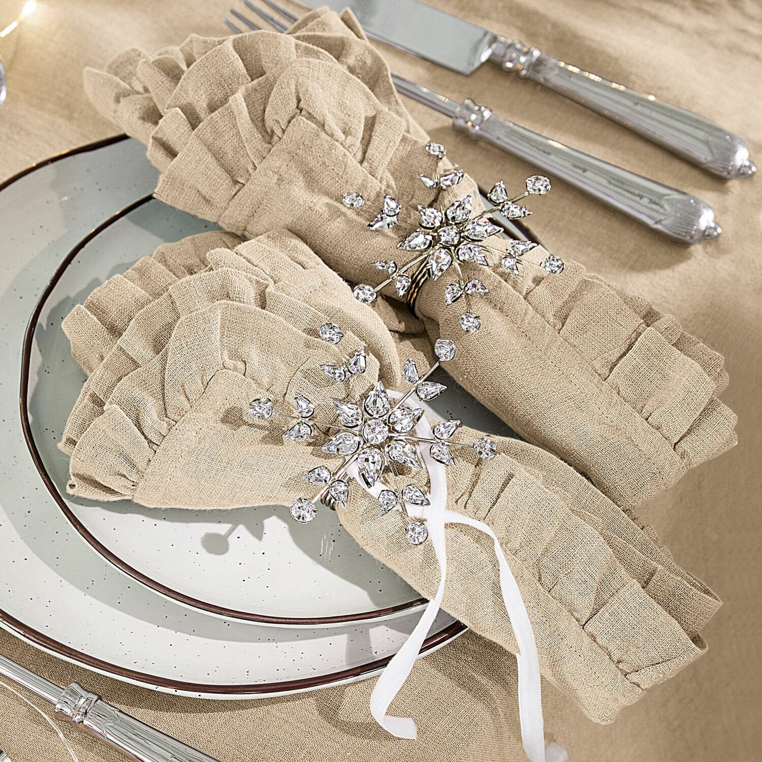 Serviettenring 2er Set Sophie Beige Leinenservietten mit Rüschen und funkelnden Kristallserviettenringen auf gedecktem Tisch