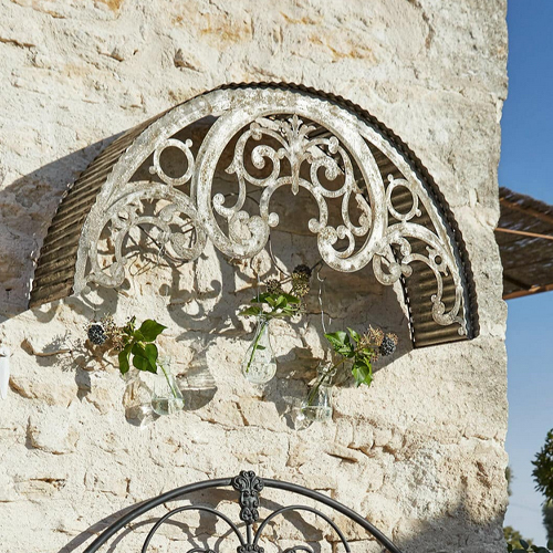Metall-Wanddekoration mit weissem Used-Look und hängenden Glasvasen für Blumen
