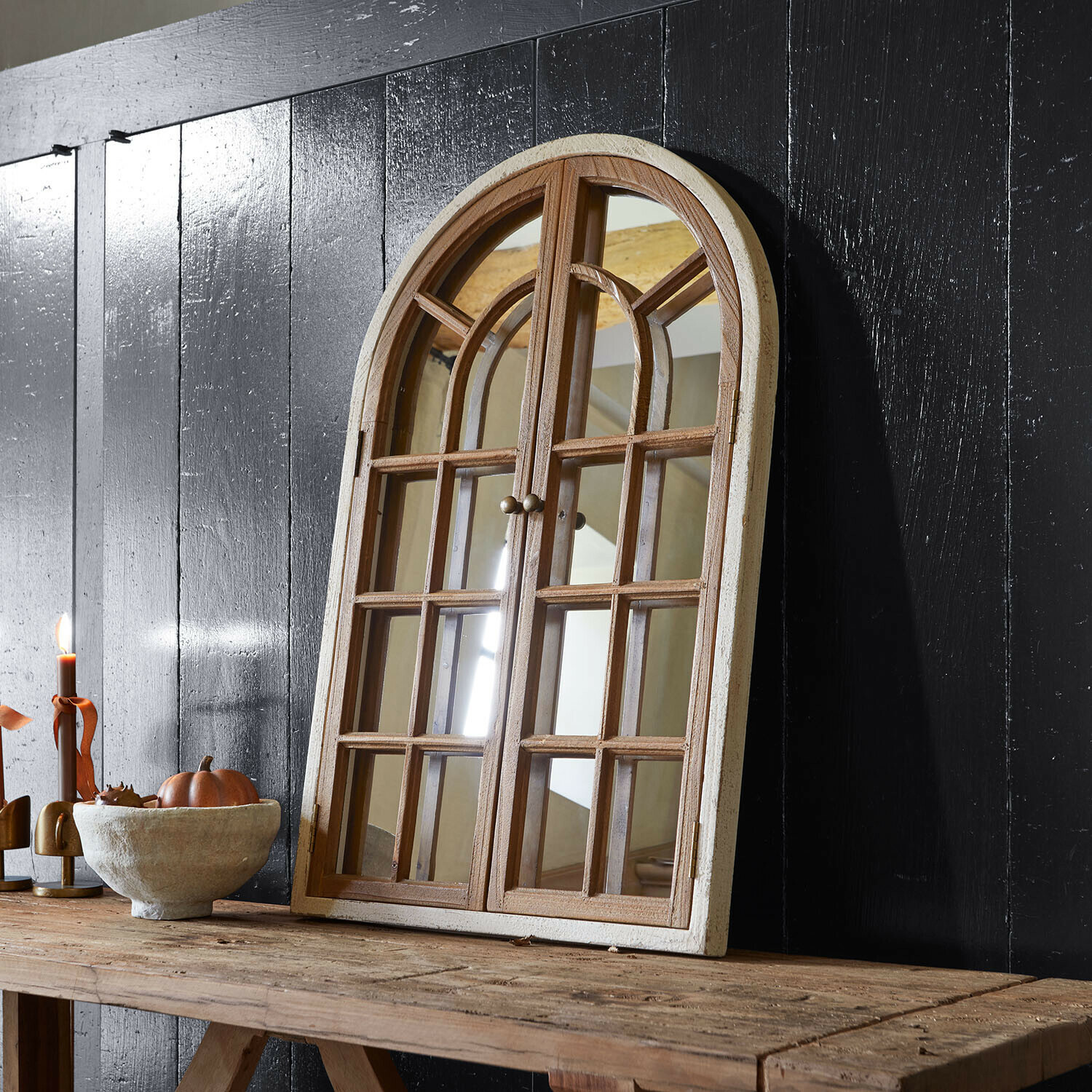 Deko-Fenster mit Spiegel Montévine Holzspiegel in Fensterform mit weissem Rahmen auf rustikalem Tisch vor schwarzer Wand