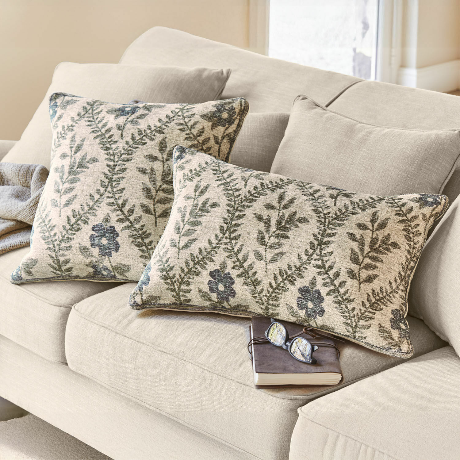 Kissenhülle 2er Set Vellouris Beiges Sofa mit zwei dekorativen Kissen aus Stoff mit grünem Blatt- und Blumenmuster