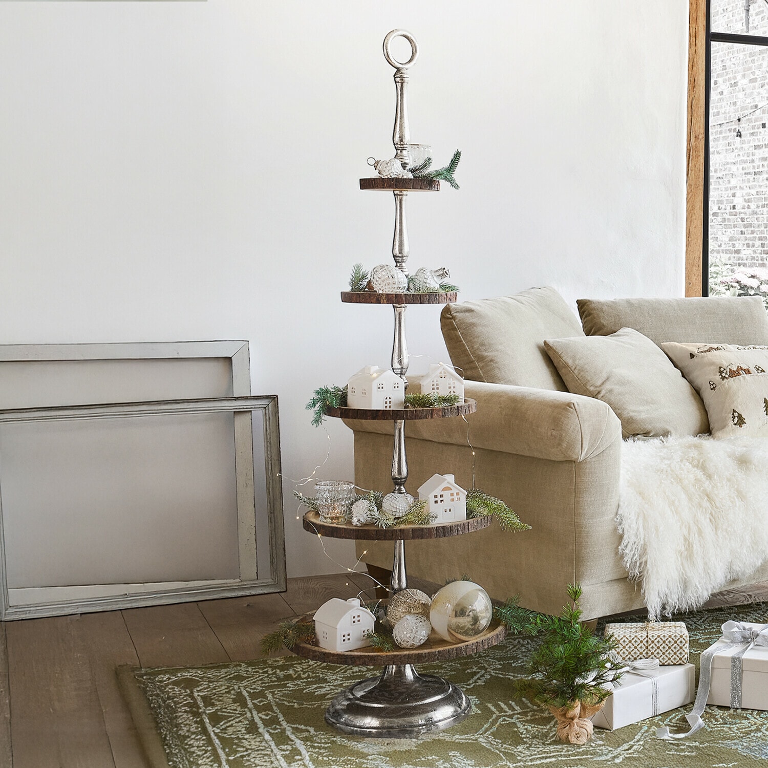 Etagere Clarette Mehrstöckiges Metall-Holz-Tablett mit Snacks neben beigem Sofa und Dekoration im Wohnzimmer
