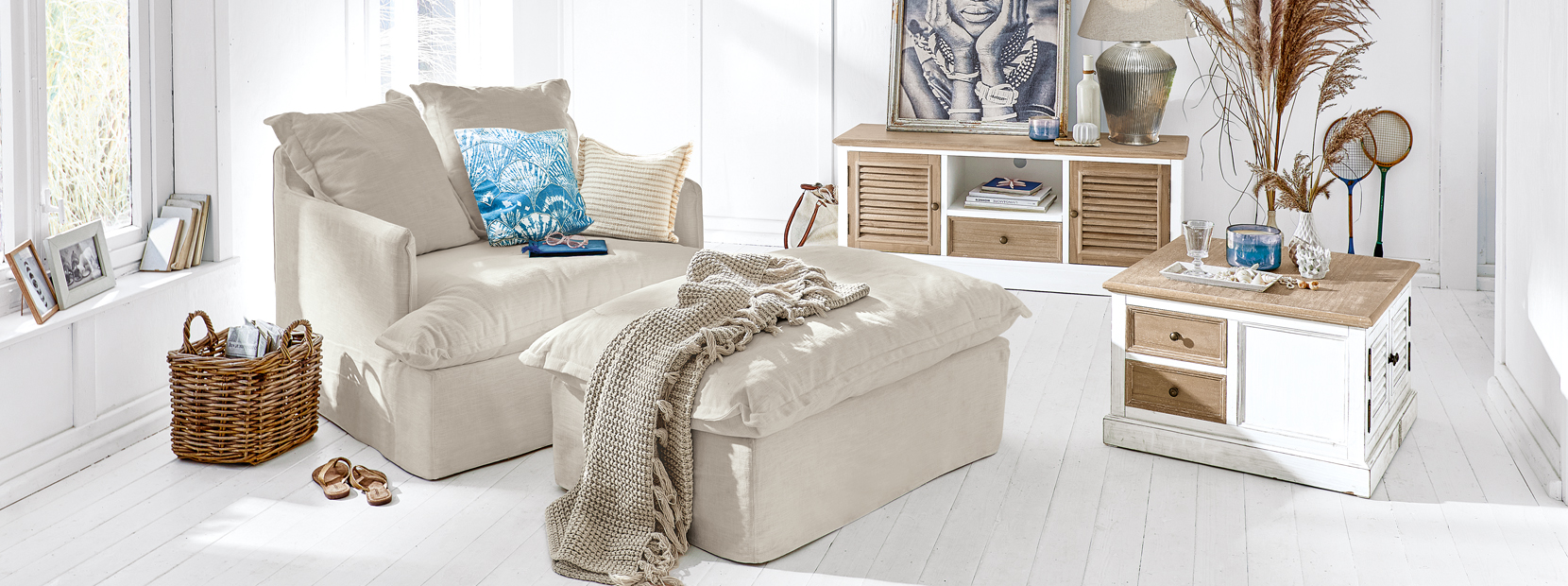Beiges Ecksofa mit Hocker und Holzmöbeln im hellen, maritimen Wohnstil