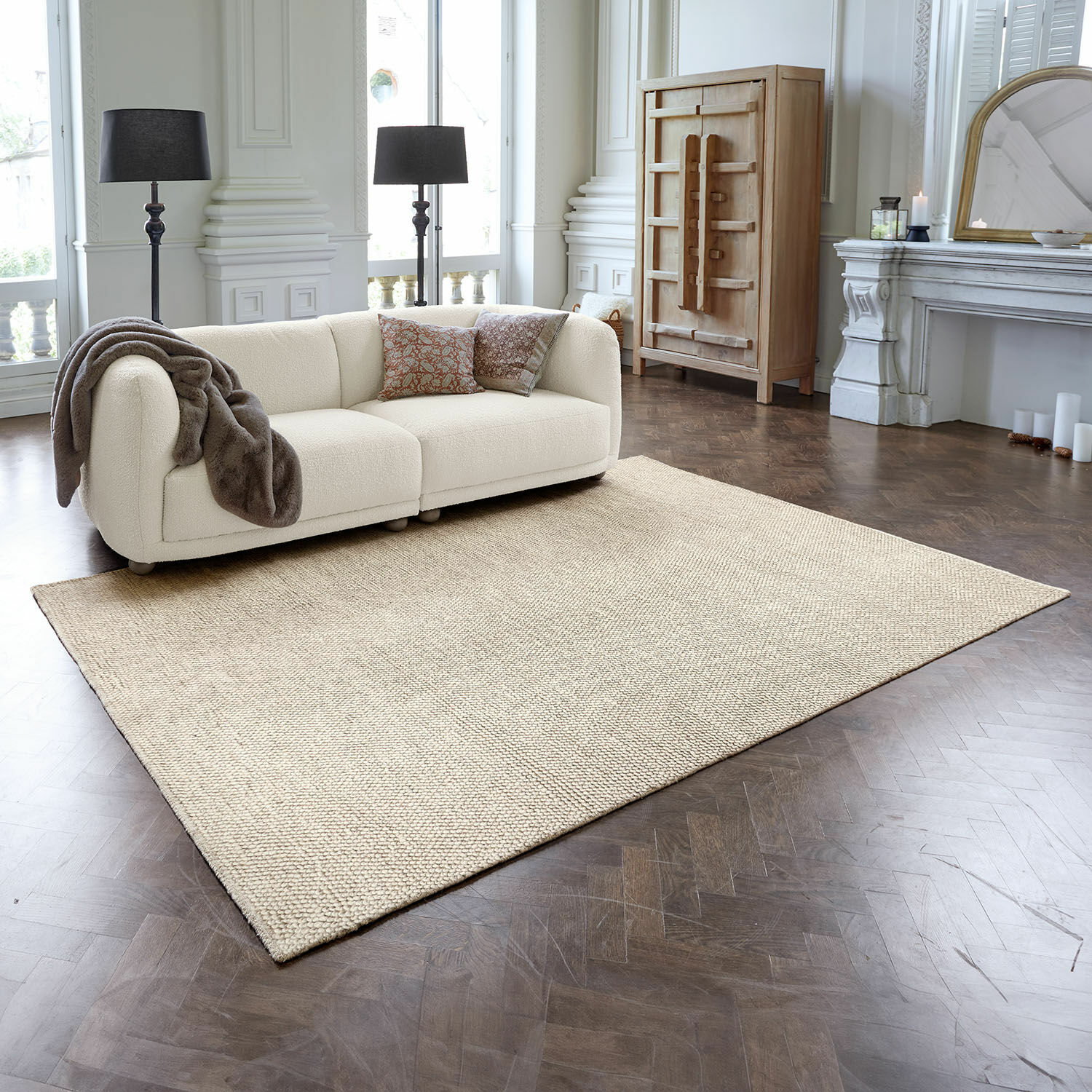 Teppich Coleman Beiger Teppich aus Naturmaterial auf dunklem Holzboden in elegantem Wohnzimmer mit Sofa