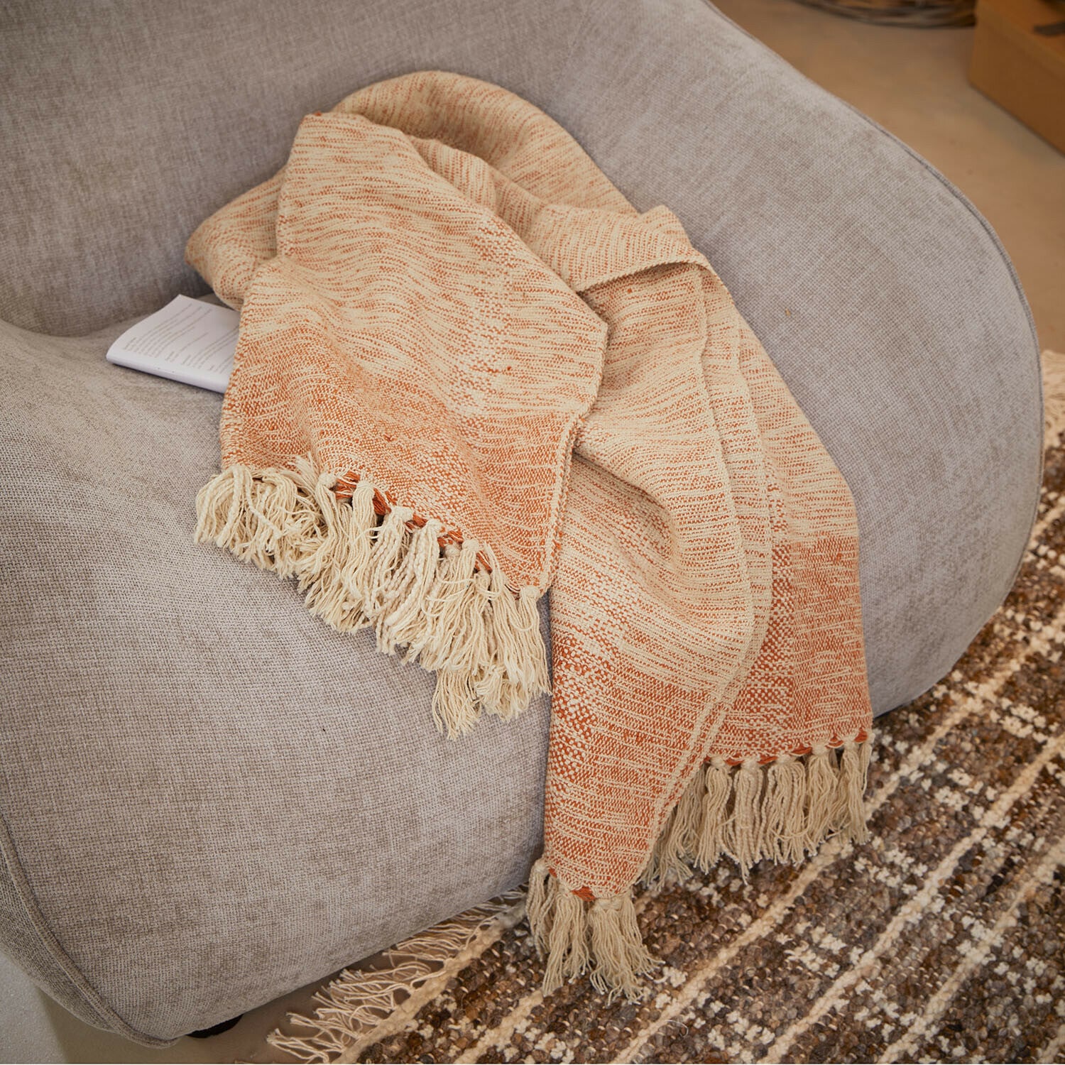 Plaid Winlow Beige-orangefarbige Decke mit Fransen auf grauem Sessel, weiches Material für Wohnraumdeko