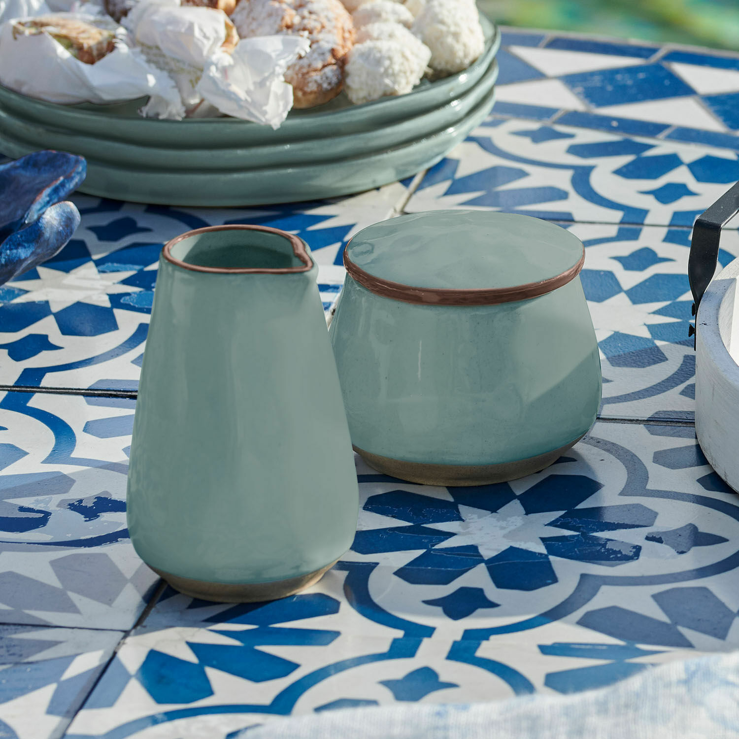 Zuckerdose und Milchkännchen Biarré Grüner Keramikkrug und Dose auf blau-weiss gemustertem Tisch