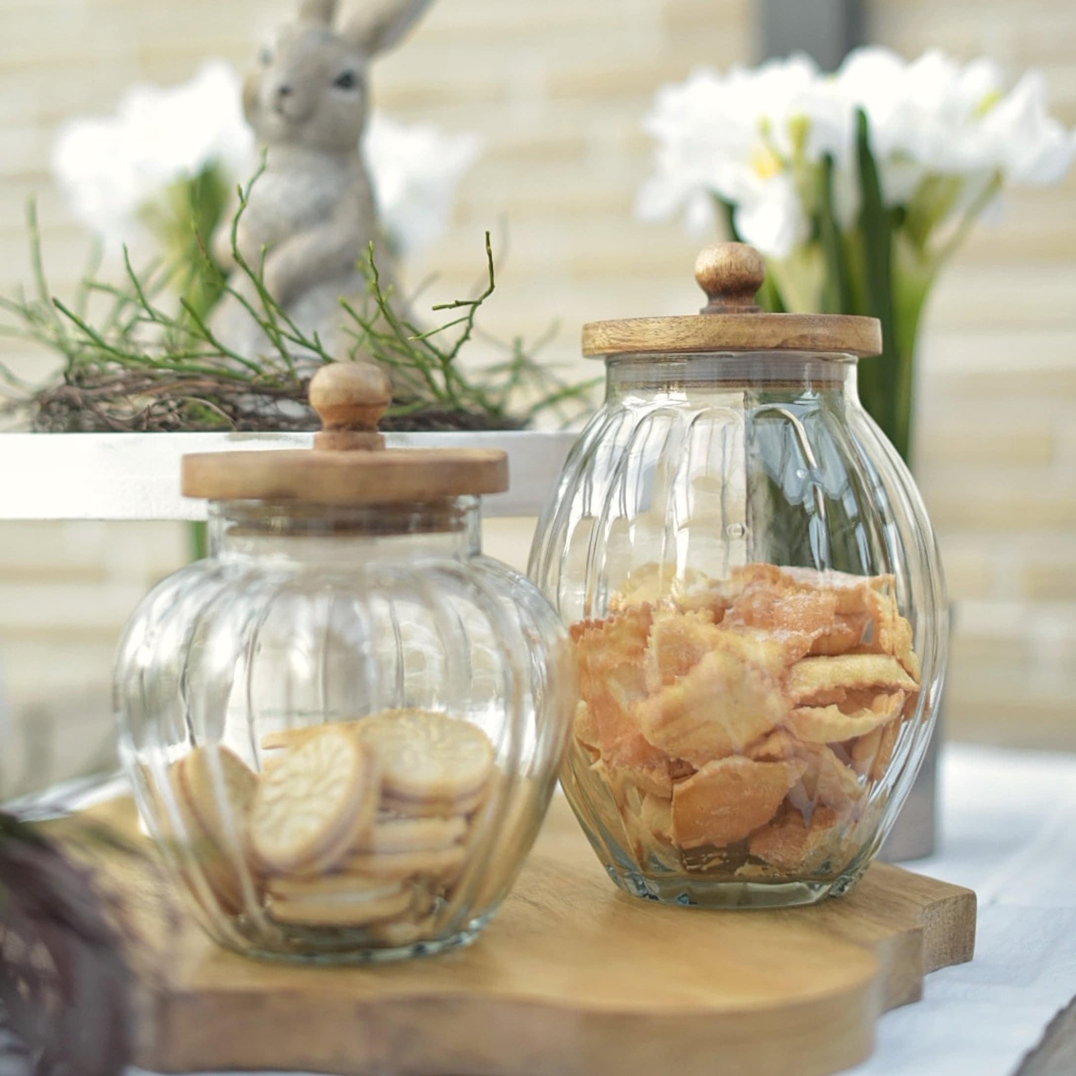 Gläser mit Holzdeckeln, gefüllt mit Keksen, natürliche Osterdekoration aus Glas und Holz
