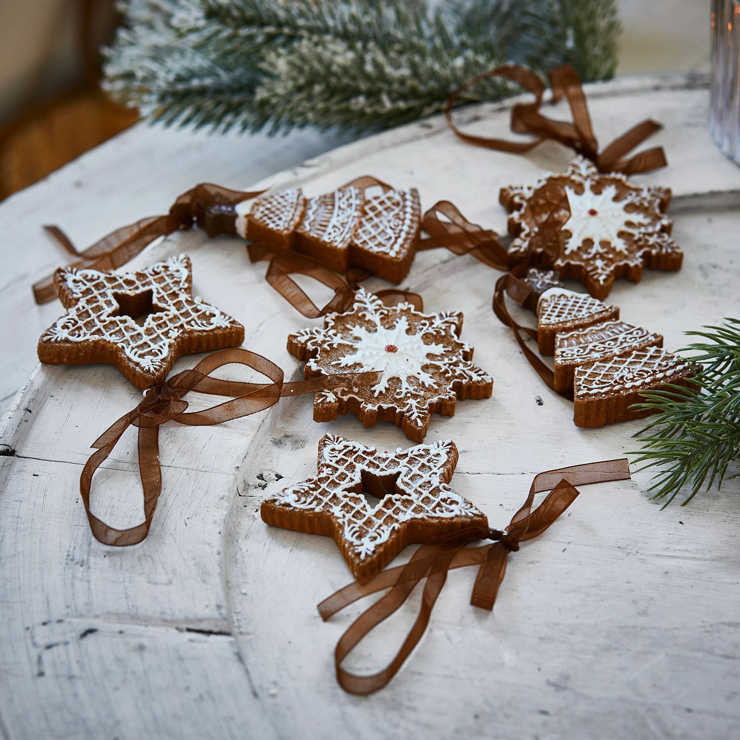 Anhänger 6er Set Chimayo Set Lebkuchen-Weihnachtsdekorationen mit weisser Glasur und braunen Bändern auf Holztisch
