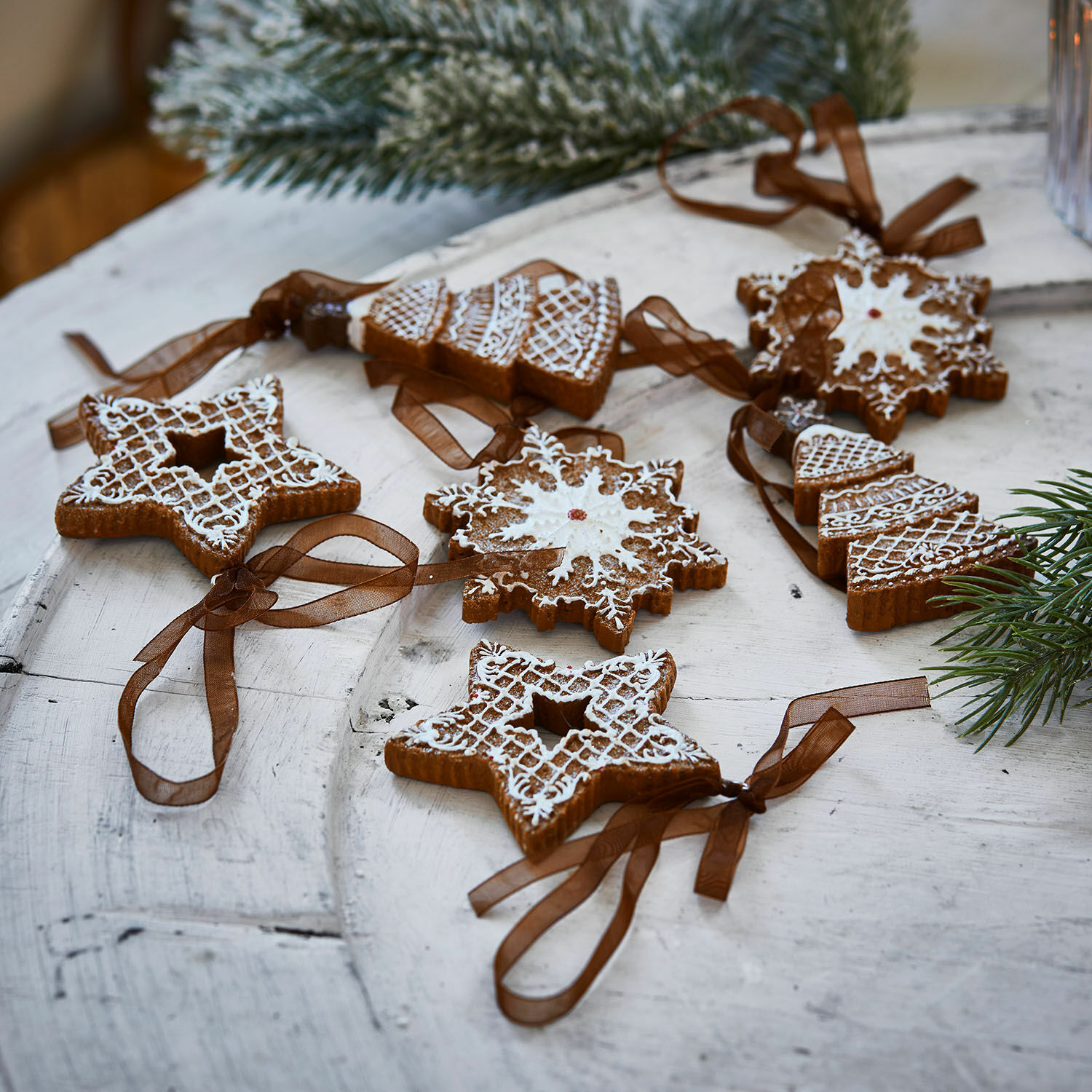 Anhänger 6er Set Chimayo Set Lebkuchen-Weihnachtsdekorationen mit weisser Glasur und braunen Bändern auf Holztisch