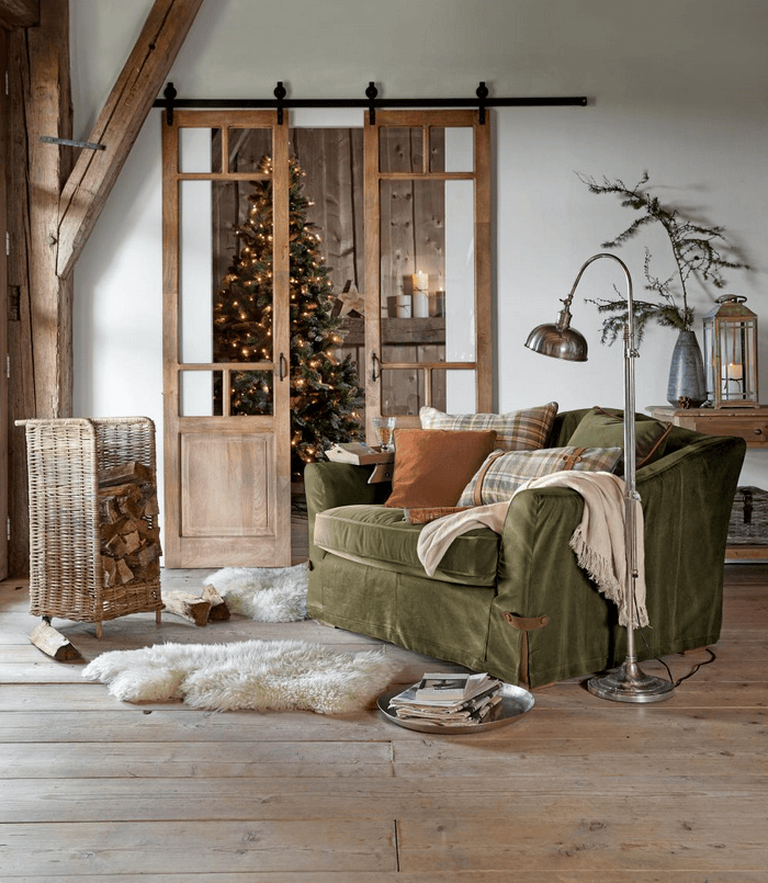 Grüner Stoffsessel im rustikalen Wohnzimmer mit Holzboden und Weihnachtsdekoration