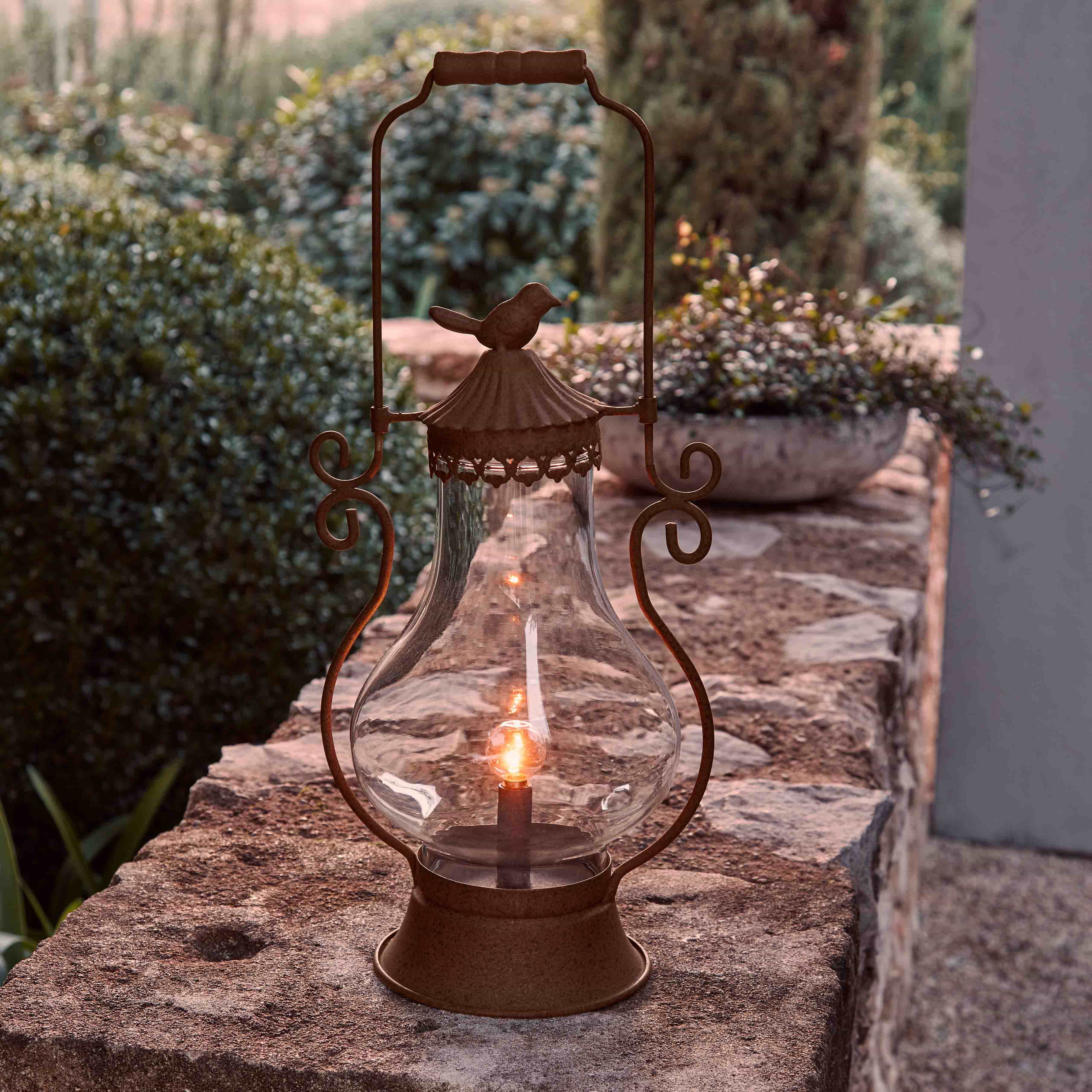 Gartenlaterne aus rostfarbenem Metall mit klarem Glas und Vogel-Dekor, stimmungsvolle Aussenbeleuchtung