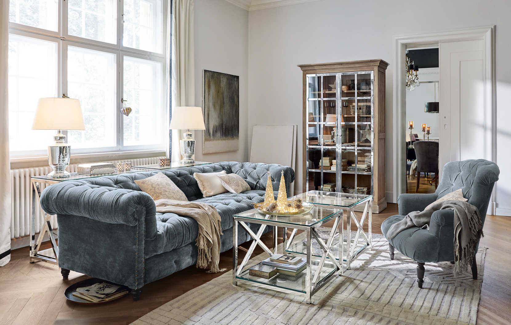 Elegantes Wohnzimmer mit blauem Samtsofa und gläsernen Beistelltischen im klassischen Stil